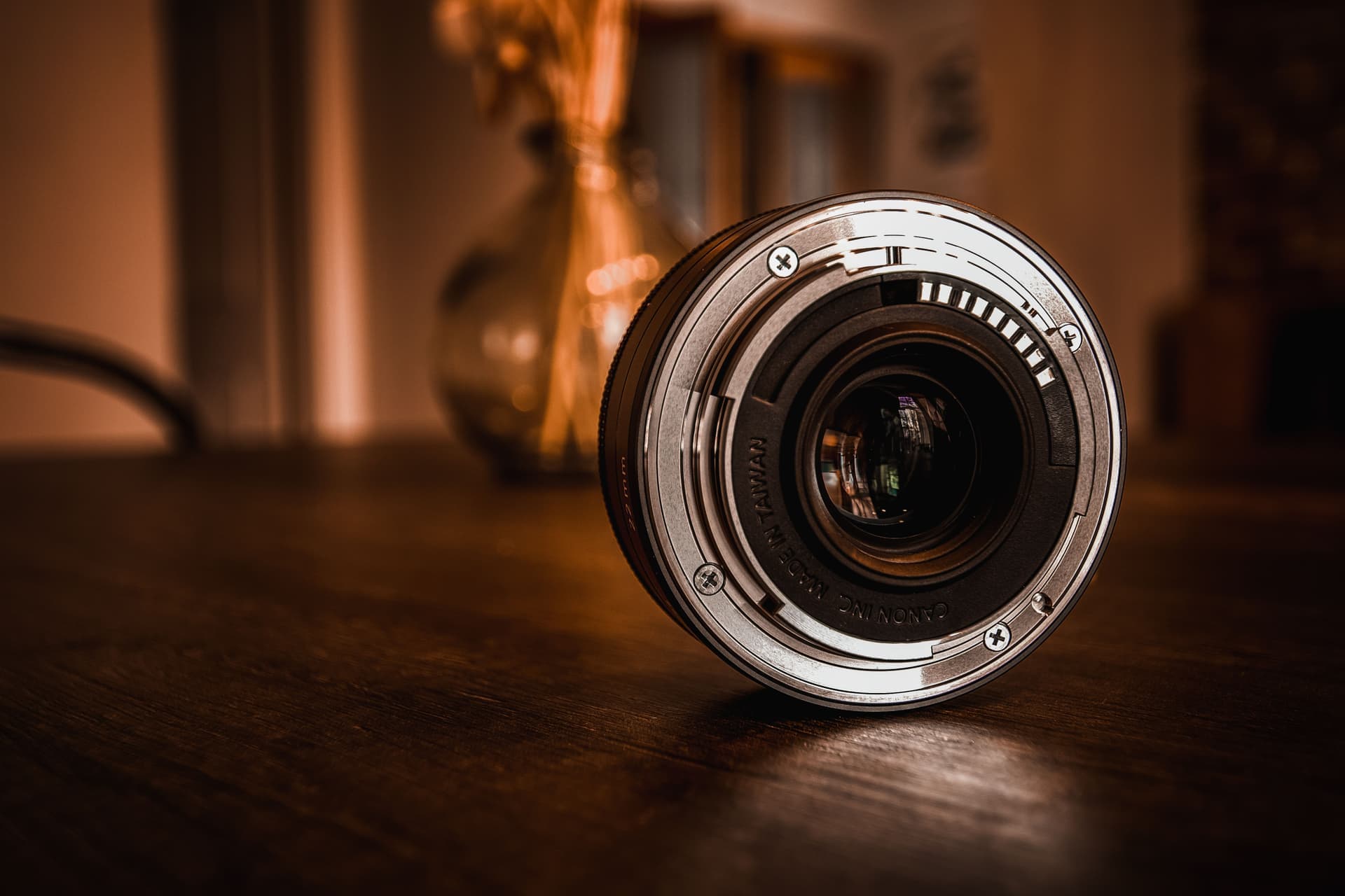 A mirrorless camera held in warm natural light with a softly blurred background
